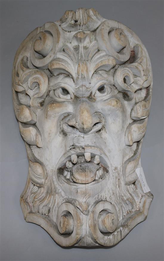 A carved wooden wall mask